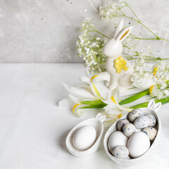 Easter. Natural eggs in figured bowls with bunny ears, ceramic bunny, white Iris, Gypsophila flowers