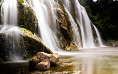 waterfall in New Zealand, long exposure with rock in foreground