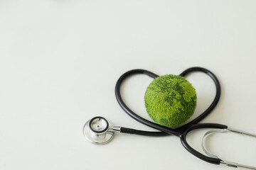 Environment Earth Day Concept.Green Earth with a medical doctor's stethoscope.Saving the environment and environmentally sustainable. saving the clean planet.Global healthcare and Green Earth Day. ESG