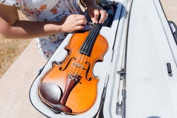 top view of unrecognizable woman putting violin in case, copy space.