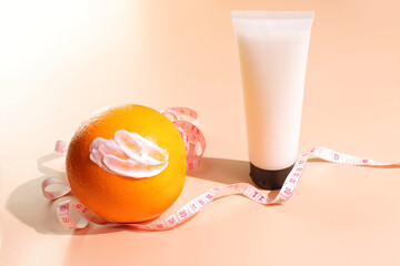 Anti cellulite concept, anticellulite cosmetic bottle mockup, smash and orange fruit