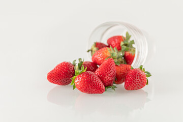 ripe sweet fragrant strawberries pouring out of a glass goblet close up shallow depth of field