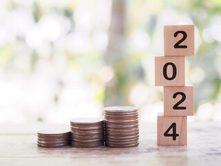 Wooden blocks with the number 2024 and stack of coins. The concept of saving money, Financial,...