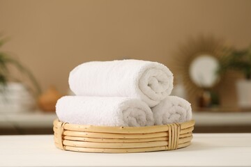 Spa composition. Rolled towels on white table indoors