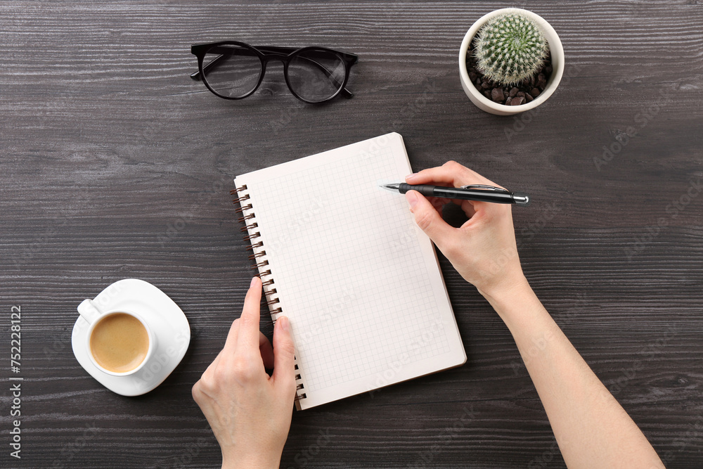 Canvas Prints Woman with notebook and pen at grey wooden table, top view. Space for text