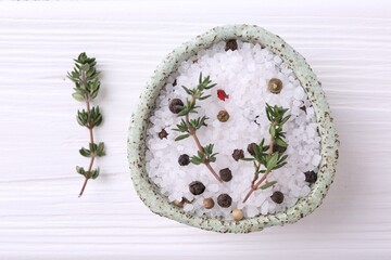 Obraz na płótnie Canvas Salt with peppercorns and thyme in bowl on white wooden table, top view