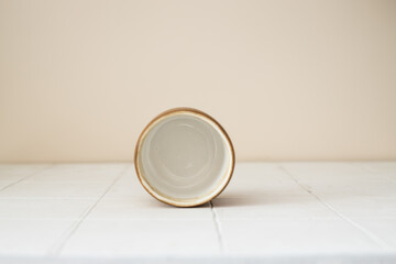 empty handmade ceramic coffee cup on beige background
