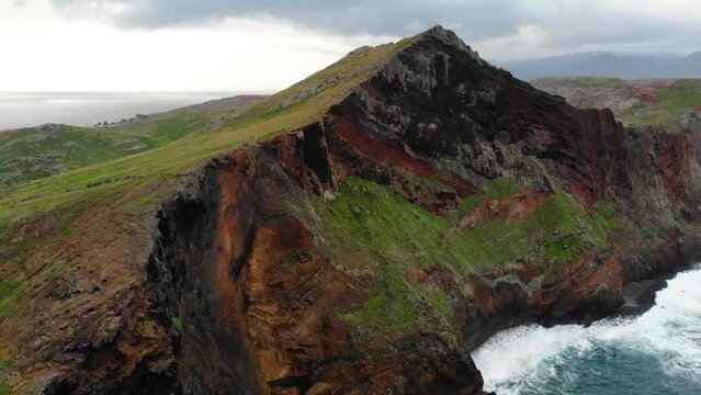 Madeira island, Portugal. Cinematic aerial view.  Beautiful landscape of Madeira island. Brown-green rocks in the ocean - Madeira easternmost point. Portugal Landmarks and landscape from above