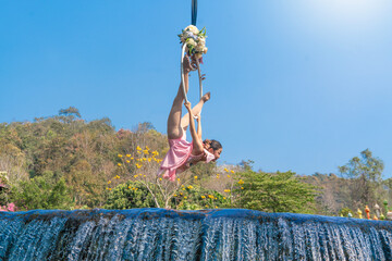 Beautiful Asian woman playing Rig and Hang Aerial Hoop for Yoga in Nature scenery.
