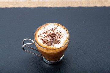 A comforting sight: a steaming cup of coffee swirled with creamy milk, inviting warmth and...