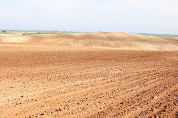 Fototapeta na wymiar Agricultural field ploughed in spring. Arable land ready for the next cultivation season