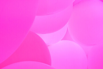 A vibrant and abstract background of overlapping pink big balloons with soft light and shadow conveying creative, playful and happy birthday celebration