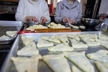 preparing arabic traditional pastries by female hands stuffing them with spinach and red chili