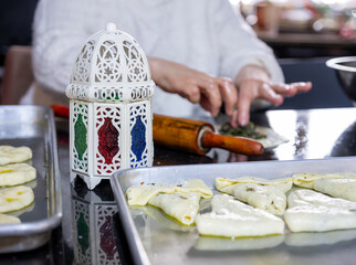 mother preparing food in kitchen during ramadan for her family , famous in front