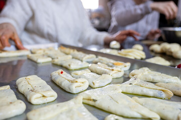 preparing arabic traditional pastries by female hands stuffing them with spinach and red chili