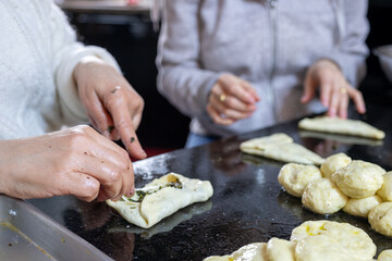 preparing arabic traditional pastries by female hands stuffing them with spinach and red chili