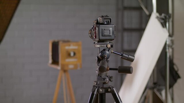 Replacing a film cassette in a medium roll format camera.  Photo studio with a professional photographer at work. Retro camera on a wooden tripod.
Photographer on a photo shoot.