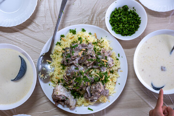 Jordanian mansaf on family table for dinner ready to be eaten looks hot and fresh with meat and almonds topping