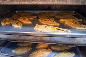 Pastries in oven being baked and freshly made of flour, olive oil and cheese, made according to...