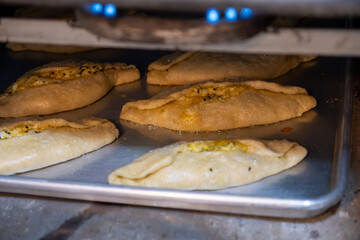 Pastries in oven being baked and freshly made of flour, olive oil and cheese, made according to jordan and palestine way