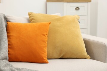 Fototapeta na wymiar Soft pillows and blanket on sofa indoors