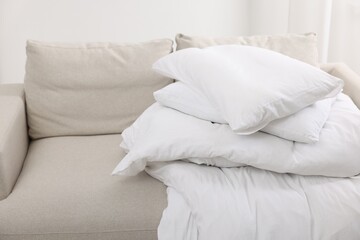 Fototapeta na wymiar Soft pillows and duvet on sofa indoors