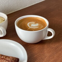 coffee cup with heart shape latte art on wood table