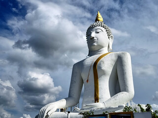 The Kakusandha Buddha image in attitude of subduing Mara on clouds in the blue sky background, is a large white Buddha statue at Wat Phai Rong Wua temple, Suphan Buri, Thailand - obrazy, fototapety, plakaty
