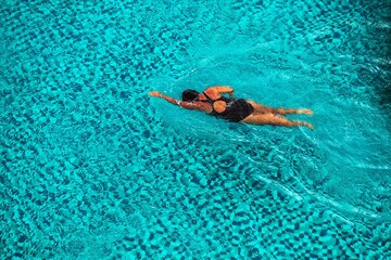 Young woman swimming in outdoor swimming pool. - 752280559
