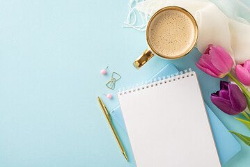 Spring awakening visual idea. Overhead view of a creamy cappuccino, fresh tulips, diary, pen, pins, and light scarf on a pastel blue backdrop with space for words or advertising