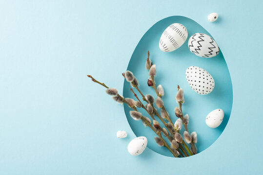 Charming Easter design idea: top view showcasing delicate pussy willows and decorated eggs, seen through an egg-shaped opening on a pastel blue canvas, space for message or ad