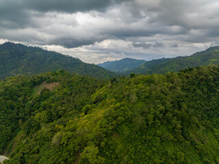 Mountain landscape on tropical island with mountain peaks covered with forest. Slopes of mountains with evergreen vegetation. Mindanao, Philippines.