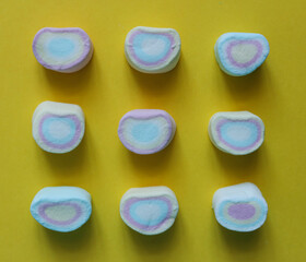 Colorful marshmallows on a yellow background. Top view.