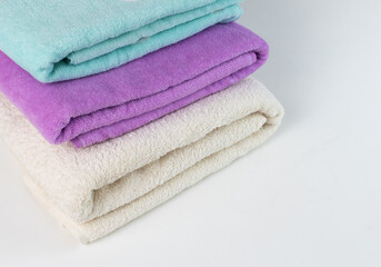 Obraz na płótnie Canvas A stack of colorful towels on a white background