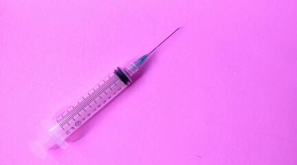 Syringe on a pink background. Close-up. Copy space.