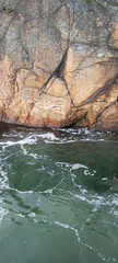 Ocean flowing near wavy rock
