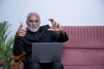 Middle age Indian asian businessman with beard wearing elegant black suit and pointing with hand...