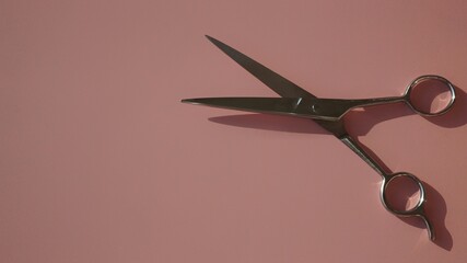 hairdressing scissors on a pink background
