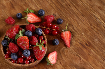 fresh berries raspberries strawberries currants on a wooden table
