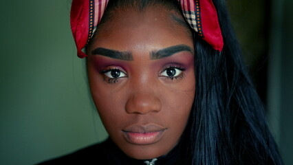 One young black latin woman looking at camera with solemn expression, close-up face of 20s adult...