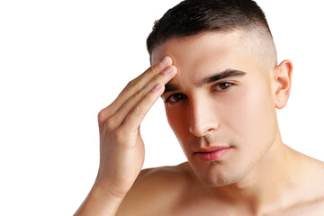 Young man standing shirtless and touching his face with hands