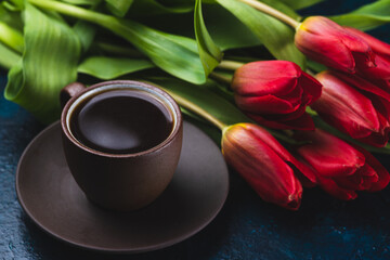 Fototapeta na wymiar a cup of coffee and a bouquet of tulips