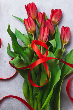 A bouquet of tulips tied with a red ribbon in the form of the number eight