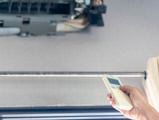 Hands of technician using remote control checking air conditioning system, Technician service fixing repair and maintenance of air conditioners