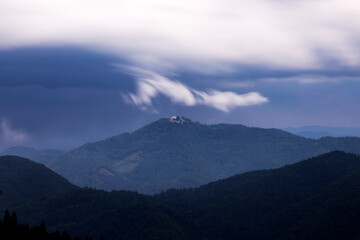 Dramatic clouds over small hiltop church in Slovenia.