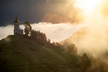 Jamnik, Slovenia - Magical foggy golden summer sunrise at Jamnik St.Primoz church.