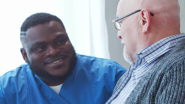 African-American caregiver and old man. Professional nurse and patient in a nursing home. Assistance, rehabilitation and health care concept.