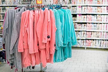 multi-colored women's robes for bathing and home in the supermarket. Fashion & Style