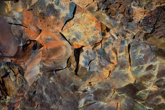 Colorful abstract mineral texture background with vibrant hues on rocky surface. Suitable for geological themes or artistic designs. Location: The Cave - Vidgelmir, Iceland.