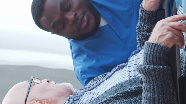 African-American caregiver and old man. Professional nurse and patient in a nursing home. Assistance, rehabilitation and health care concept.
